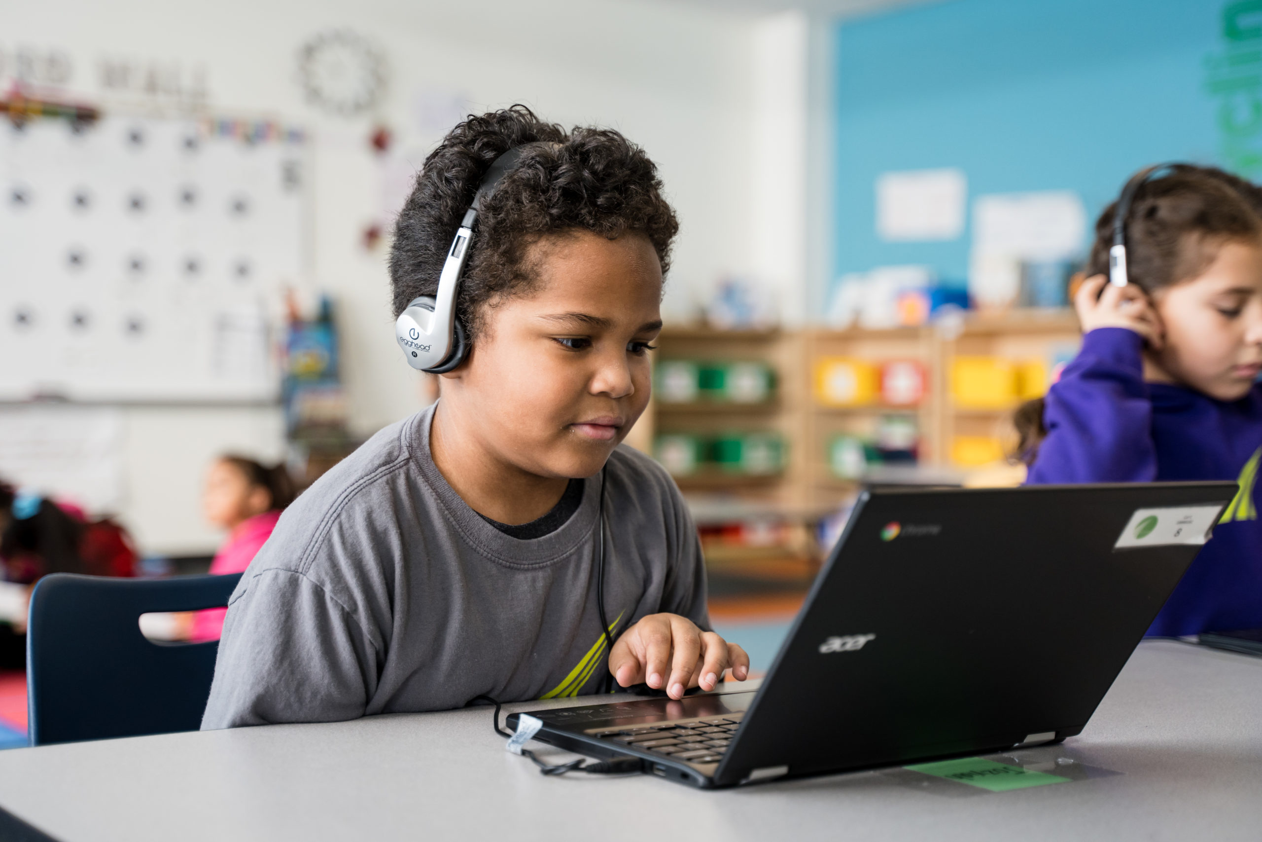 Child with headphones and computer remote learning