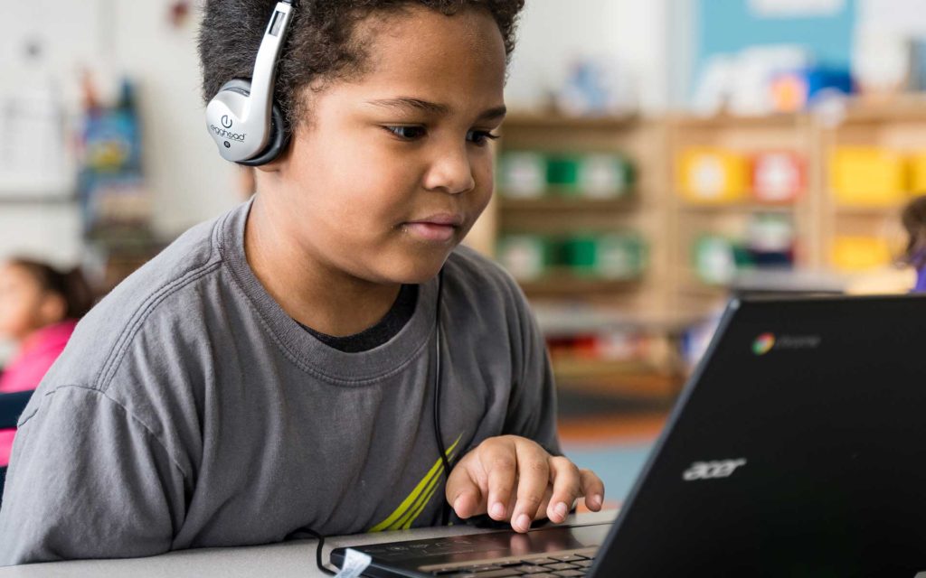 Boy with headphones and computer, remote learning